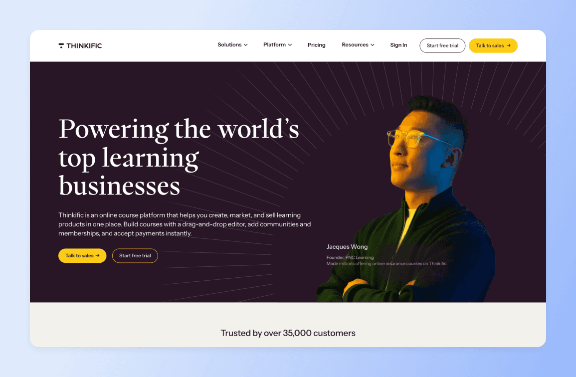 Thinkific homepage featuring Jacques Wong, Founder of PNC Learning, wearing yellow glasses against dark background with radiating lines and text "Powering the world's top learning businesses